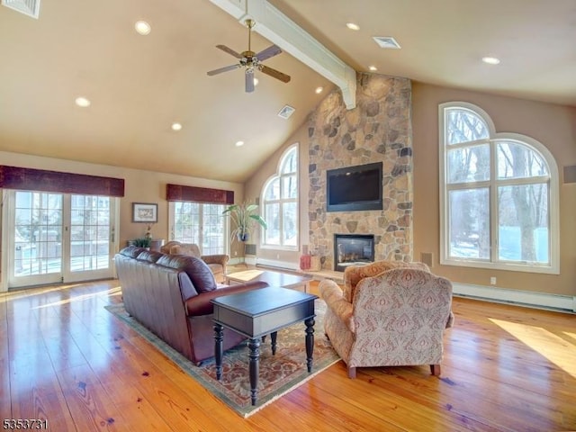 living room with a baseboard radiator, visible vents, beam ceiling, light wood finished floors, and a fireplace