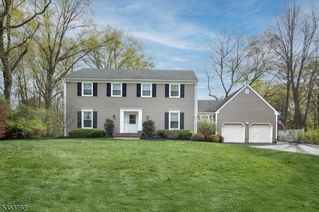 colonial inspired home with concrete driveway, a front yard, and an attached garage