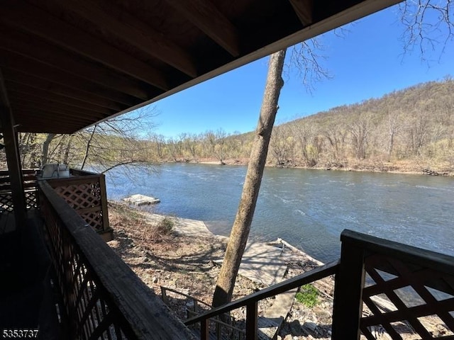 dock area featuring a wooded view and a water view