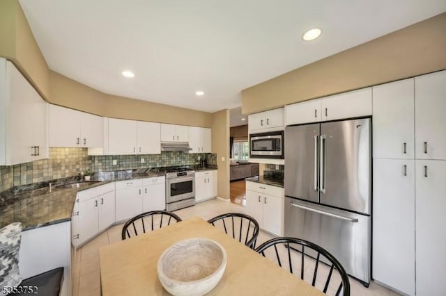 kitchen featuring recessed lighting, white cabinets, tasteful backsplash, a sink, and appliances with stainless steel finishes