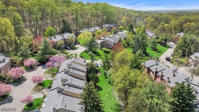 birds eye view of property featuring a forest view and a residential view