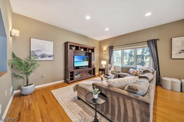 living room with baseboards, recessed lighting, and light wood-style flooring