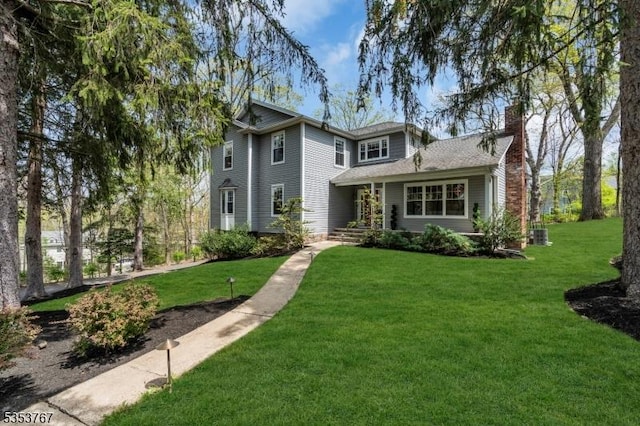 traditional home with a chimney and a front lawn