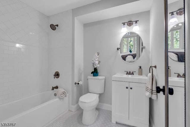 bathroom with vanity, toilet, tile patterned floors, baseboards, and tub / shower combination