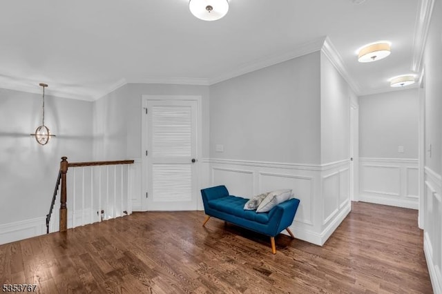 unfurnished room with crown molding, an upstairs landing, wainscoting, and wood finished floors