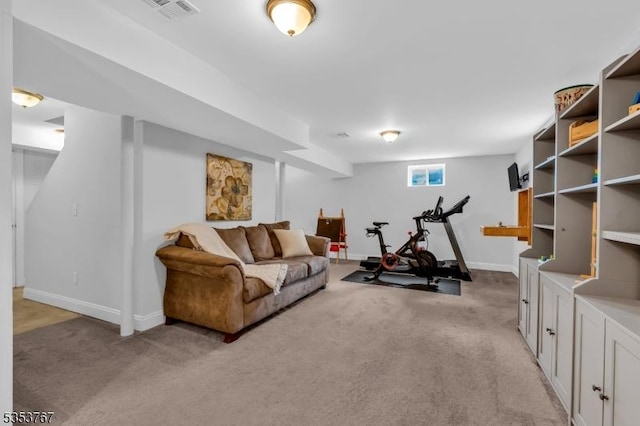 exercise area with visible vents, baseboards, and light carpet