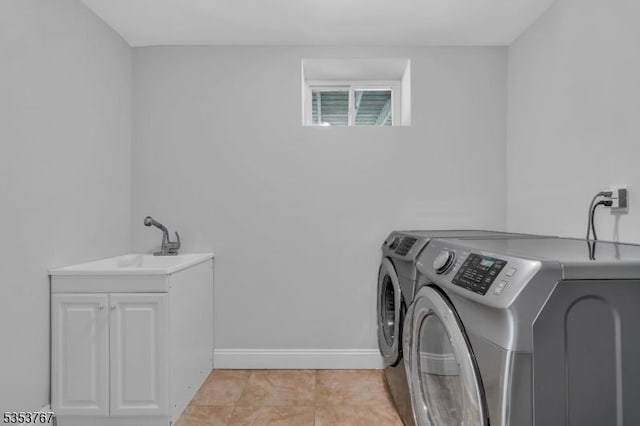 clothes washing area with light tile patterned floors, baseboards, cabinet space, and washer and dryer