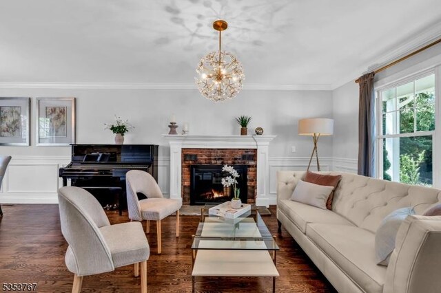 living room featuring crown molding, a chandelier, wainscoting, and dark wood-type flooring