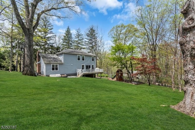 rear view of house featuring a yard, a deck, and a chimney