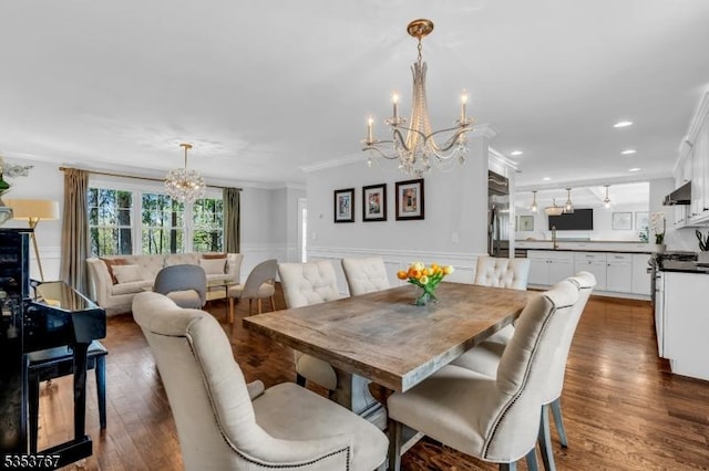 dining area featuring crown molding, an inviting chandelier, wainscoting, recessed lighting, and dark wood-type flooring