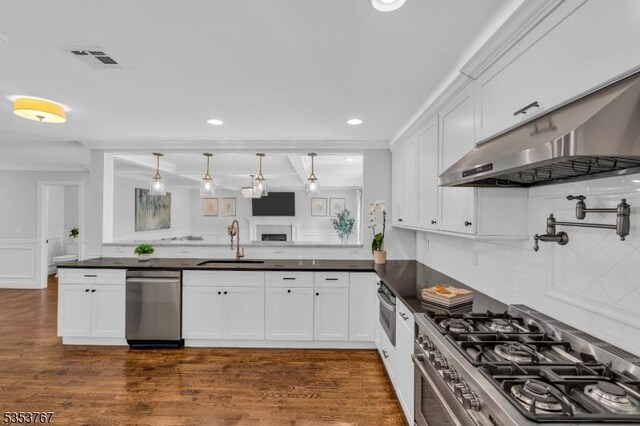 kitchen with white cabinets, dark countertops, appliances with stainless steel finishes, and a sink