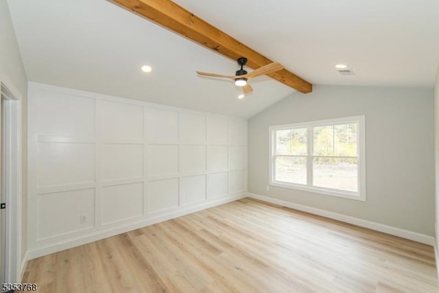 empty room with vaulted ceiling with beams, ceiling fan, light wood-style flooring, and a decorative wall