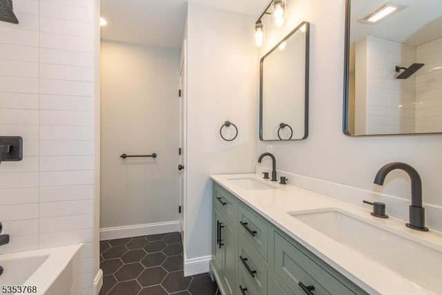 bathroom with double vanity, baseboards, tile patterned flooring, and a sink