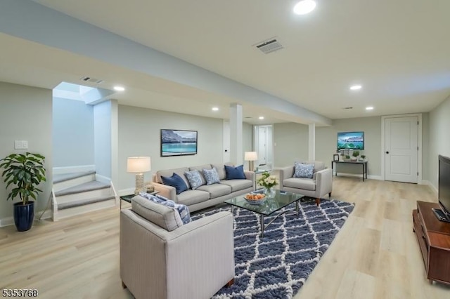 living area featuring baseboards, visible vents, light wood-style floors, and recessed lighting