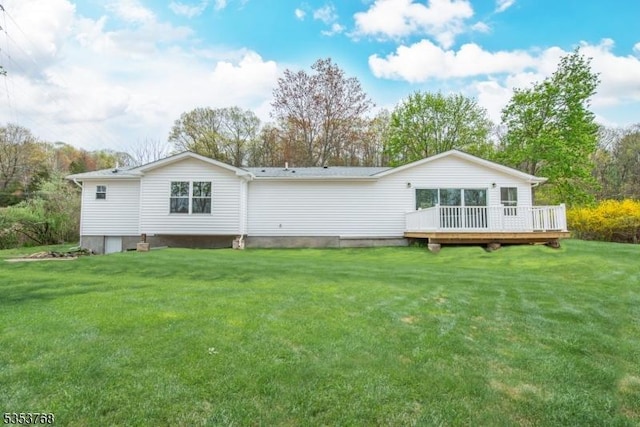 rear view of house featuring a wooden deck and a lawn