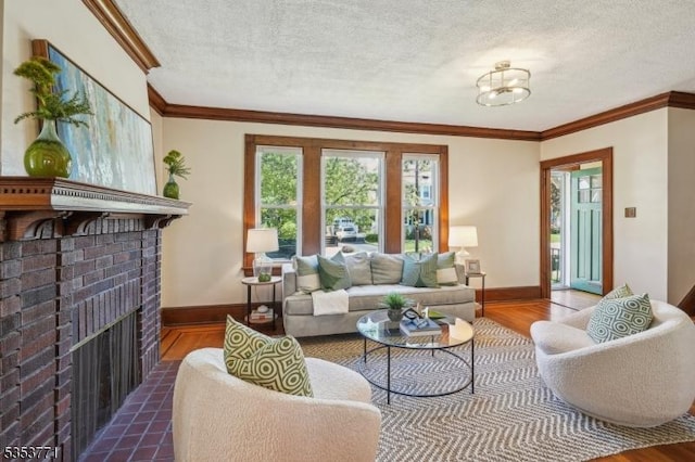 living area featuring ornamental molding, wood finished floors, baseboards, a textured ceiling, and a fireplace