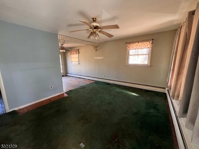 carpeted spare room featuring ceiling fan, baseboards, and a baseboard radiator