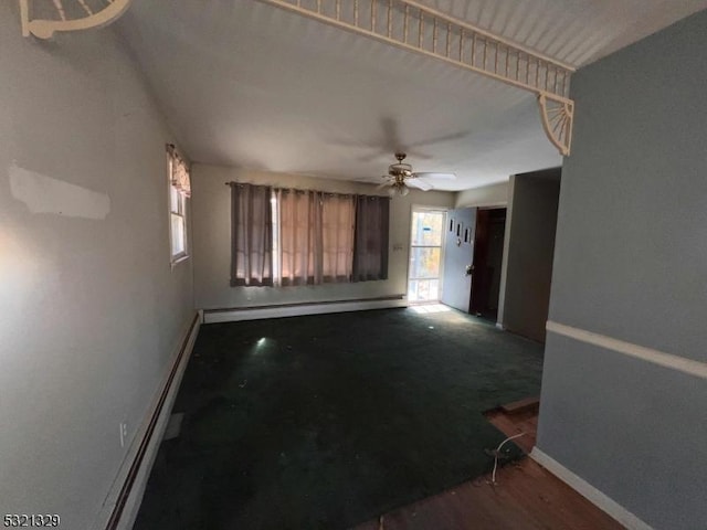 spare room featuring a ceiling fan, baseboards, a baseboard heating unit, and a wealth of natural light