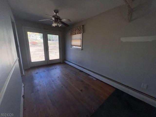 spare room featuring french doors, a ceiling fan, baseboards, wood finished floors, and a baseboard heating unit