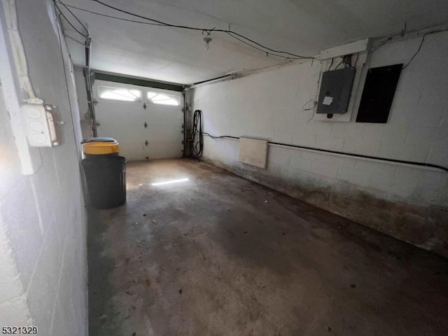 garage featuring electric panel and concrete block wall