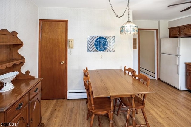dining area featuring a baseboard heating unit, ceiling fan, light wood-style flooring, and a baseboard radiator