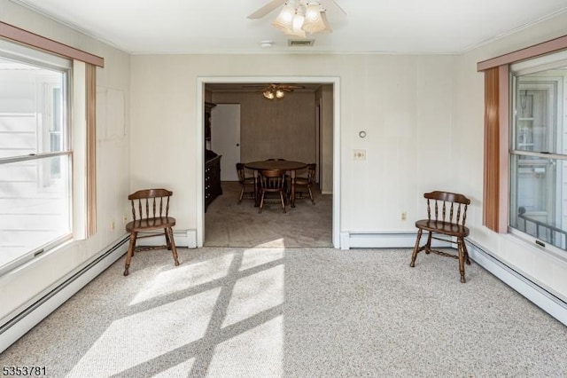 living area with a ceiling fan, visible vents, baseboard heating, and carpet floors