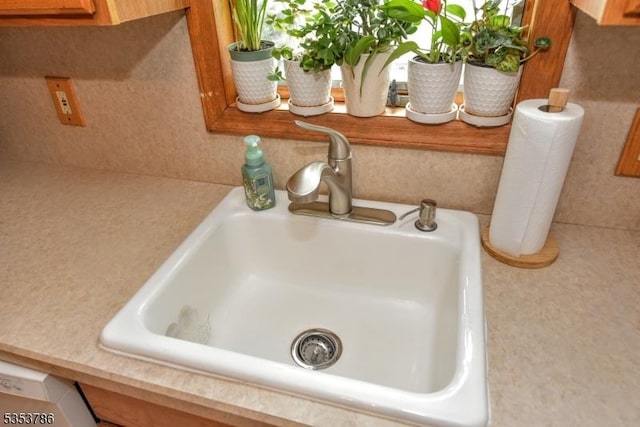 details with a sink, light countertops, and brown cabinets