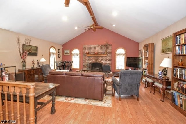 living room with a ceiling fan, light wood-style flooring, lofted ceiling with beams, and a fireplace