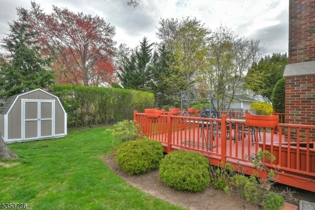 view of yard featuring a wooden deck, a storage unit, and an outdoor structure