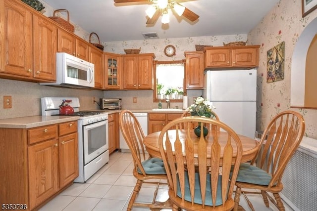 kitchen featuring light countertops, ceiling fan, white appliances, and wallpapered walls