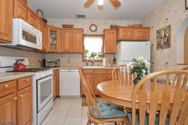 kitchen featuring visible vents, white appliances, wallpapered walls, light countertops, and a sink