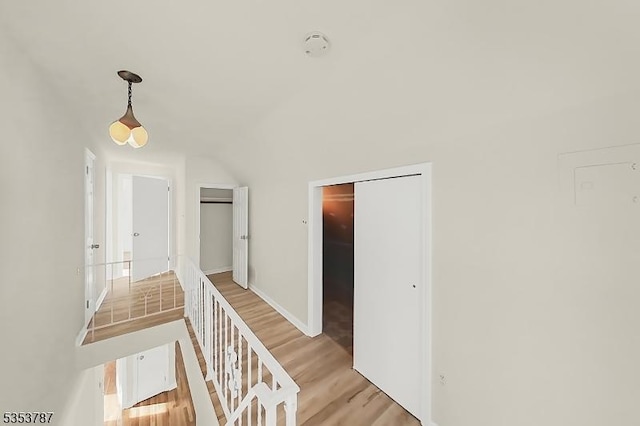 corridor with baseboards and light wood finished floors