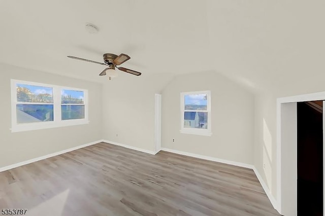 additional living space featuring wood finished floors, ceiling fan, plenty of natural light, and vaulted ceiling