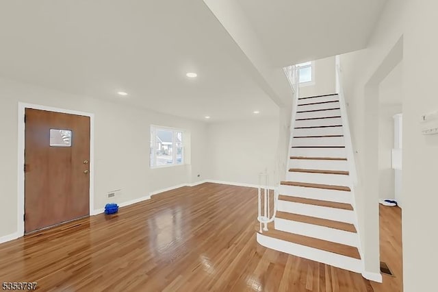 foyer with baseboards, light wood-type flooring, stairs, and recessed lighting