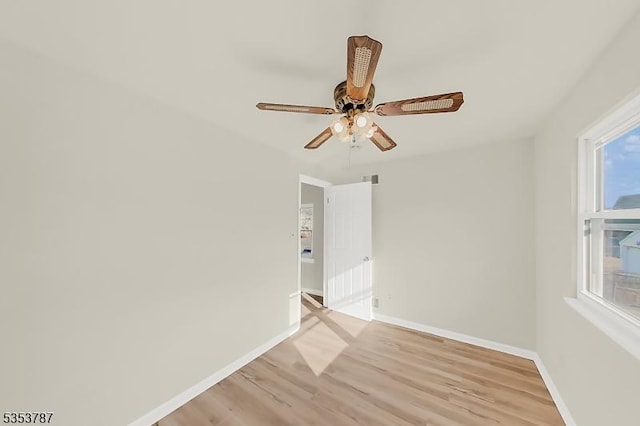 spare room with baseboards, ceiling fan, and light wood-style flooring