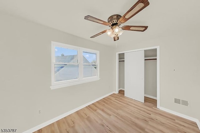 unfurnished bedroom featuring a closet, visible vents, wood finished floors, and baseboards