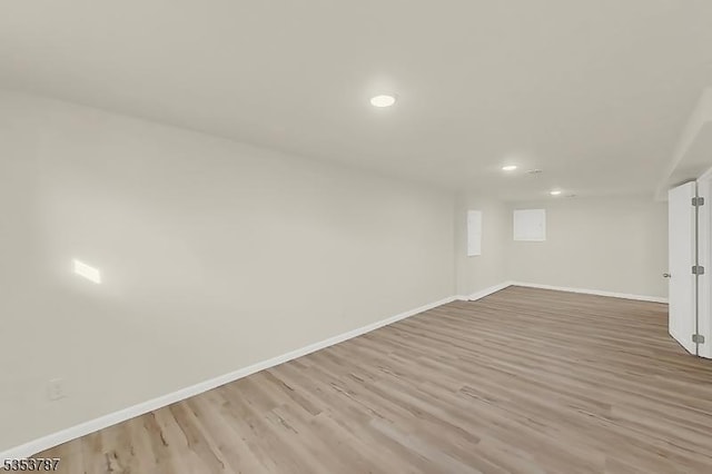 finished basement featuring recessed lighting, light wood-style flooring, and baseboards
