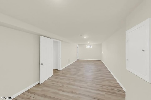 finished below grade area featuring light wood-style floors, recessed lighting, and baseboards