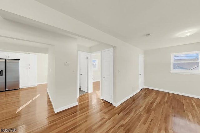 empty room featuring baseboards and light wood-style flooring