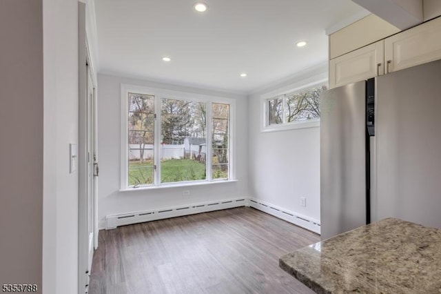 unfurnished dining area featuring dark wood-style flooring, baseboards, recessed lighting, and ornamental molding