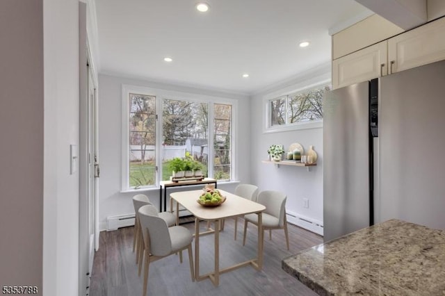 dining space with recessed lighting, baseboards, baseboard heating, and wood finished floors