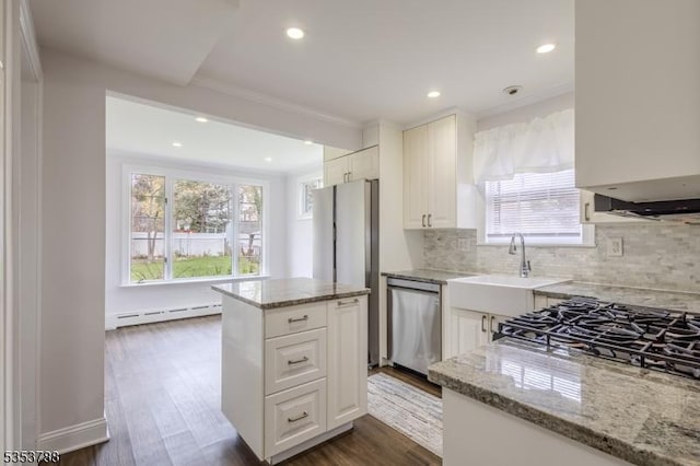 kitchen with backsplash, a baseboard heating unit, light stone counters, and dishwasher