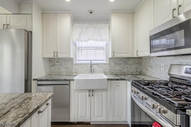 kitchen featuring decorative backsplash, light stone countertops, stainless steel appliances, and white cabinetry
