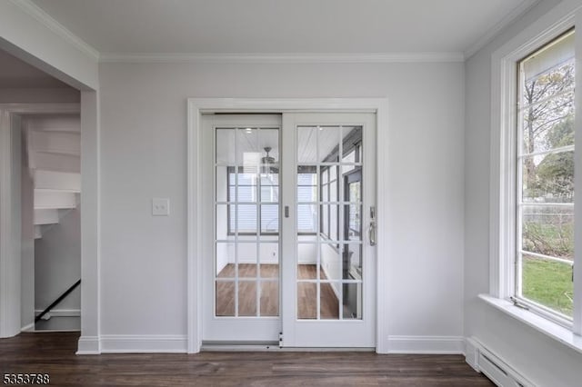 doorway with crown molding, baseboards, a baseboard heating unit, and dark wood-type flooring