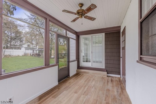 unfurnished sunroom with baseboards, ceiling fan, wood finished floors, and wooden ceiling