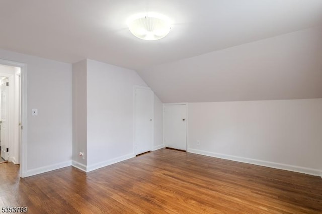 bonus room featuring baseboards, lofted ceiling, and wood finished floors