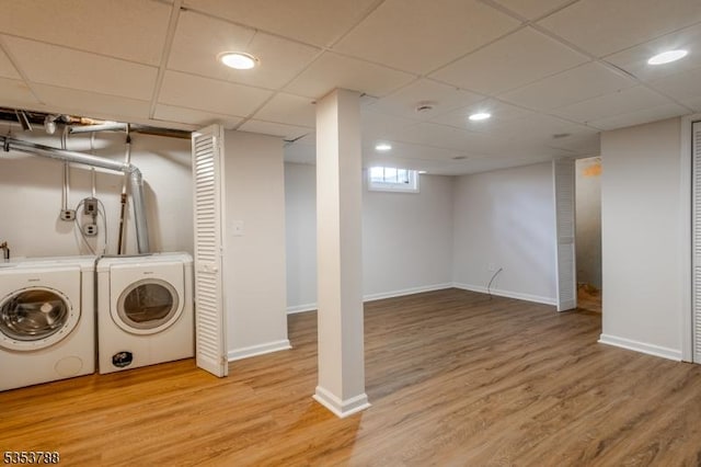 laundry room with baseboards, laundry area, wood finished floors, and washing machine and clothes dryer
