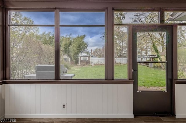 doorway featuring plenty of natural light, baseboards, and wood finished floors