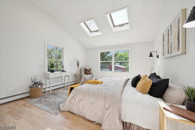 bedroom with wood finished floors, a baseboard heating unit, multiple windows, and a skylight
