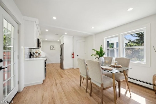 dining space with recessed lighting, light wood-style flooring, a healthy amount of sunlight, and baseboard heating
